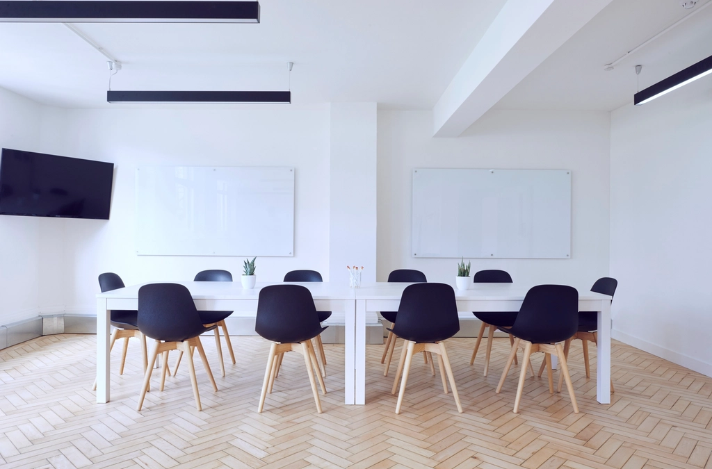 Bright conference room with two whiteboards set up for planning meetings